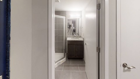 A bathroom with a sink, mirror, and tiled floor.